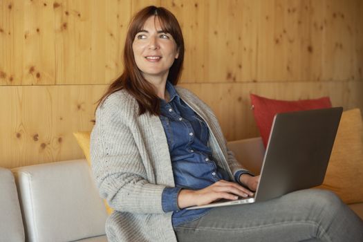 Woman working on a laptop on a cozy space