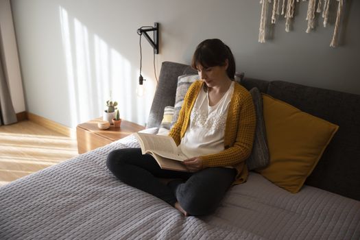 Beautiful woman on bed and reading a book