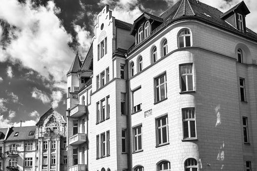 A street with historic, Art Nouveau tenement houses in the city of Poznan, black and white