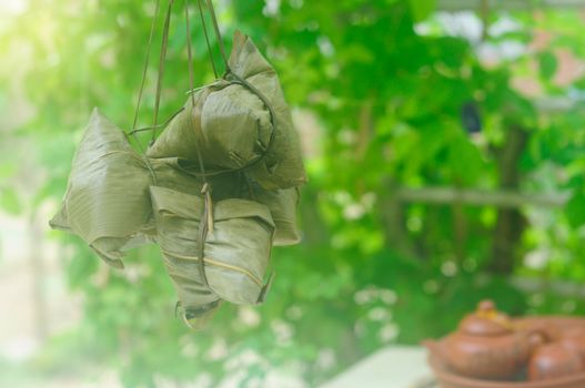 Chinese tradition food - Chinese Steamed Rice Dumpling  with bokeh background outdoor.Zongzi or traditional chinese sticky rice dumpling usually taken during festival occasion. 