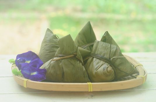 Chinese tradition food - Chinese Steamed Rice Dumpling  with blur background outdoor.Zongzi or traditional chinese sticky rice dumpling usually taken during festival occasion. 