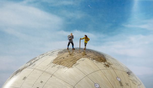 little figures backpaking australia as a big adventure with backpack and walking on a globe