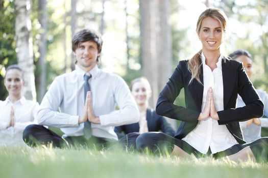 Business people team practicing yoga in park