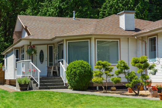 Fragment of a nice house with entrance door and landscape in the front. Canada