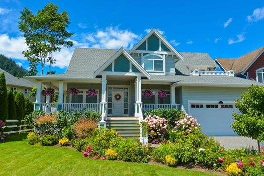 A perfect neighborhood. Residential house with patio and garage on blue sky background. Family house in British Columbia, Canada