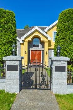 Entrance of luxury family house with cast iron gates in front. Vancouver, Canada