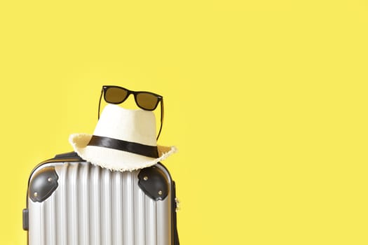 Travel bag, Luggage, Straw hat and sunglasses on yellow background with copy space. suitcase, hat , black sunglasses isolated on yellow background. Summer  travel concept.