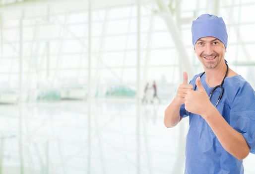 Happy male doctor showing thumbs up, at the hospital