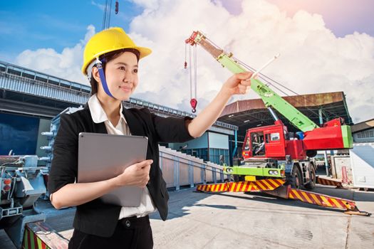 Young woman engineer holding digital tablet wtih smile in construction site background