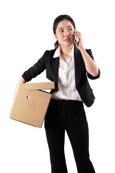 A young woman carrying a box and talking on the phone