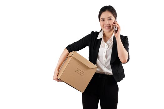 A young woman carrying a box and talking on the phone