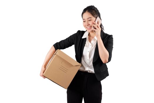 A young woman carrying a box and talking on the phone