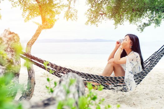 Beautiful woman sitting on a swing on the beach  in Koh Phangan, Thailand