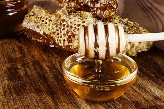 Yellow Honey and Honeycomb slice on a wooden table