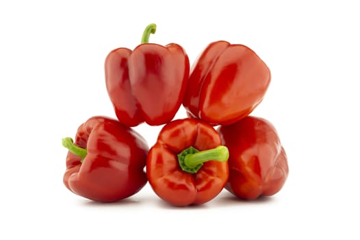 A stack of red bell peppers isolated on white background