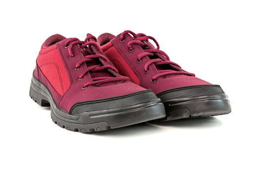 a pair of cheap cheap crimson red hiking shoes isolated on white background - perspective close-up view.