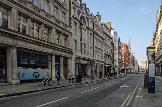 London, UK - April 24, 2020:  Shops and cafes on Little Portland Street in the Fitzrovia district of central London on a late Spring day.