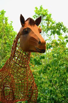Modern sculpture made of rusty wire; a garden sculpture representing a horse