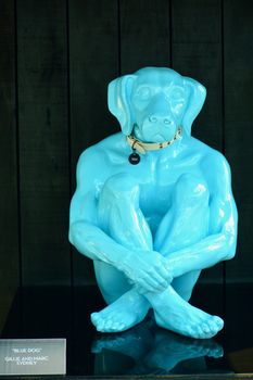 A peculiar modern sculpture representing a blue figure with a human body but a dog’s head.