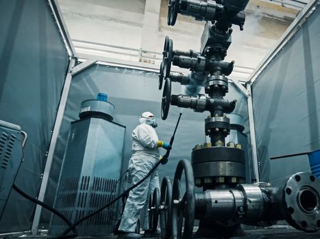 Assembling a well at the oil equipment plant. The connection of the valves and other well parts in the assembly hall.