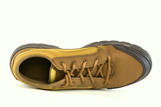 one right cheap yellow fabric hiking shoe isolated on white background.