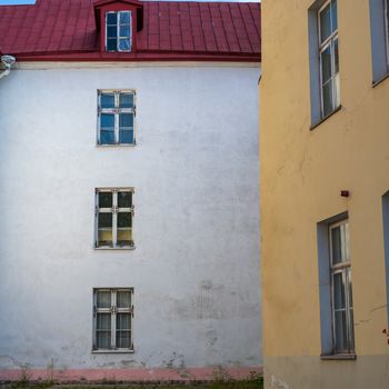 Photo of a white and yellow walls of  two buildings at roght angles to each other.