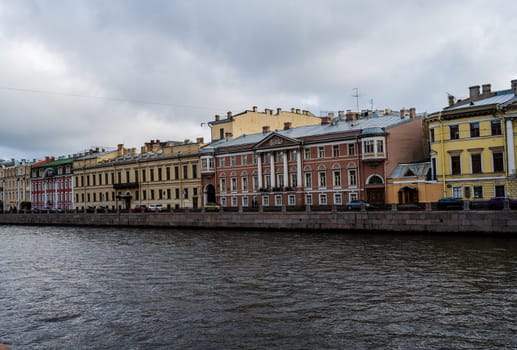 Colorful buildings line Griboedov Canal on an overcast summer day in St Petersburg.