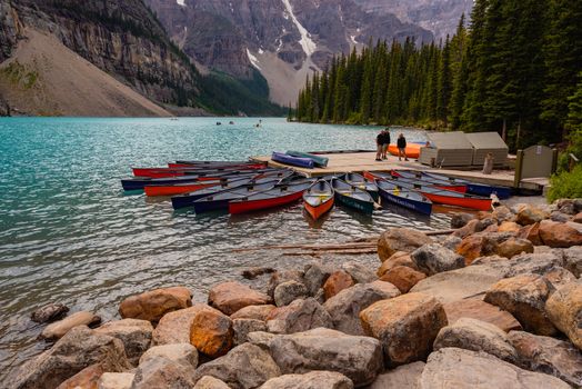 Banff, Canada--August 6, 2018.  Wide angle shot of a small pier at Moraine Lake where tourists rent canoes and kayaks to go boating.