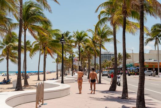 Fort Lauderdale, Florida--April 30, 2018. A man and woman walk along beach boulevard on a sunny morning.