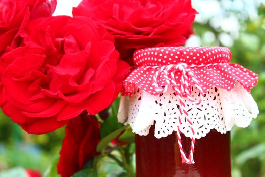 The picture shows rose jelly and blossoming roses