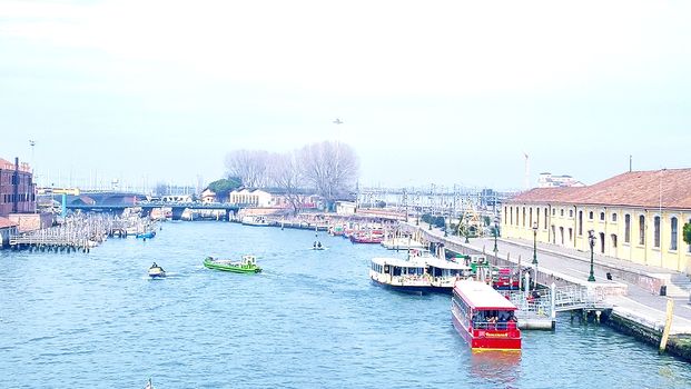 Venice, Italy - 04/24/2019: Foggy (misty) Venice. Canal (channel), historical, old houses and gondoliers with gondolas in thick fog. Scenic cityscape view. Venice. Italy. Copy space. Empty place for message. Outdoor.