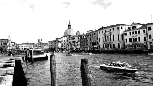 Venice, Italy - 04/24/2019: Foggy (misty) Venice. Canal (channel), historical, old houses and gondoliers with gondolas in thick fog. Scenic cityscape view. Venice. Italy. Copy space. Empty place for message. Outdoor.