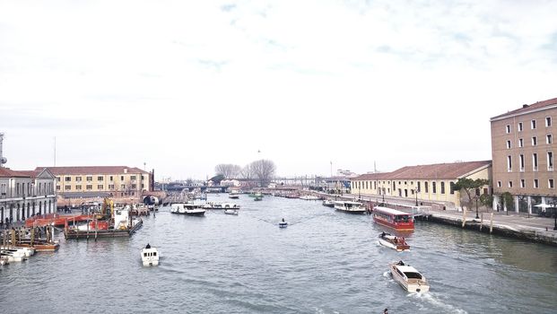 Venice, Italy - 04/24/2019: Foggy (misty) Venice. Canal (channel), historical, old houses and gondoliers with gondolas in thick fog. Scenic cityscape view. Venice. Italy. Copy space. Empty place for message. Outdoor.