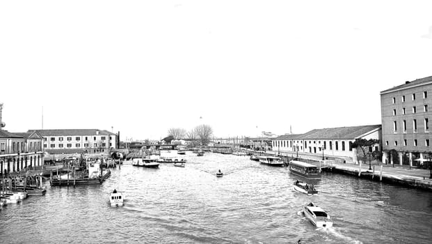 Venice, Italy - 04/24/2019: Foggy (misty) Venice. Canal (channel), historical, old houses and gondoliers with gondolas in thick fog. Scenic cityscape view. Venice. Italy. Copy space. Empty place for message. Outdoor.