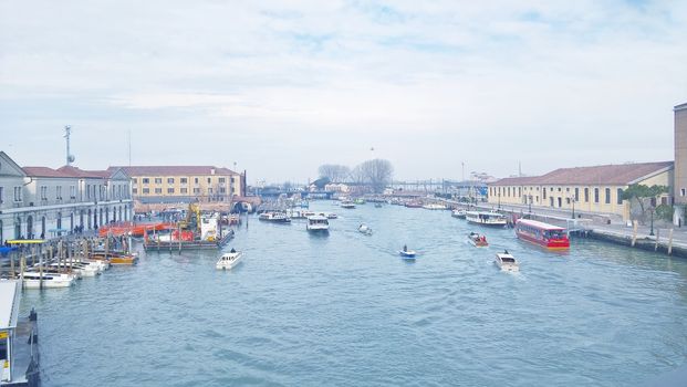 Venice, Italy - 04/24/2019: Foggy (misty) Venice. Canal (channel), historical, old houses and gondoliers with gondolas in thick fog. Scenic cityscape view. Venice. Italy. Copy space. Empty place for message. Outdoor.