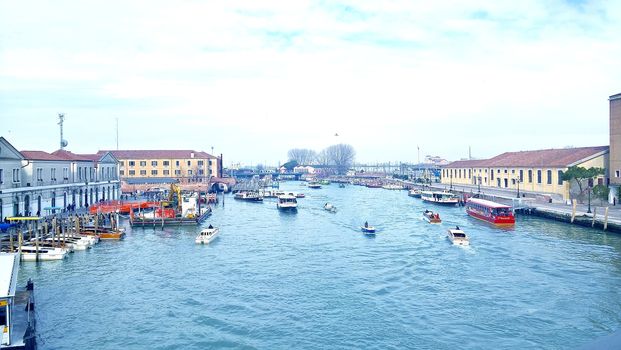 Venice, Italy - 04/24/2019: Foggy (misty) Venice. Canal (channel), historical, old houses and gondoliers with gondolas in thick fog. Scenic cityscape view. Venice. Italy. Copy space. Empty place for message. Outdoor.