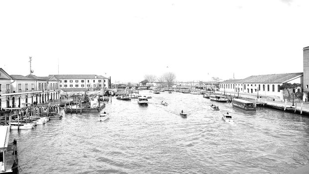 Venice, Italy - 04/24/2019: Foggy (misty) Venice. Canal (channel), historical, old houses and gondoliers with gondolas in thick fog. Scenic cityscape view. Venice. Italy. Copy space. Empty place for message. Outdoor.