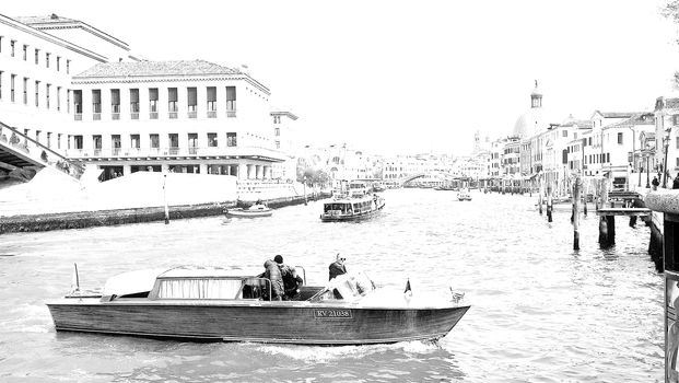 Venice, Italy - 04/24/2019: Foggy (misty) Venice. Canal (channel), historical, old houses and gondoliers with gondolas in thick fog. Scenic cityscape view. Venice. Italy. Copy space. Empty place for message. Outdoor.