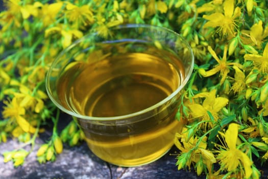 The picture shows herb tea on an old weathered tree trunk