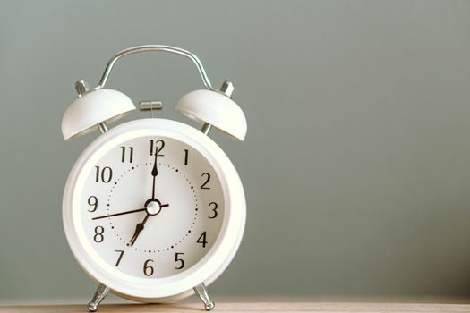 Alarm clock on white table with soft light in the morning, selective