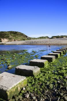 Stepping Stones at Three Cliffs Bay beach on the Gower Peninsular West Glamorgan Wales UK, which is a popular Welsh coastline travel destination of outstanding beauty 