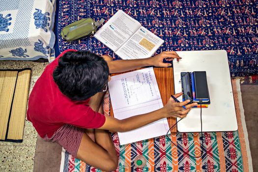 Pune,  India - June 2nd, 2020 : Student pursuing online education through cell phone  due to closed schools on account of spread of pandemic COVID-19, corona virus in Pune, Maharashtra, India.