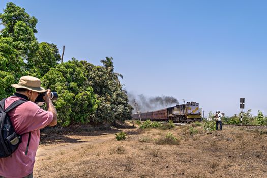 Talala, Gujrat, India - April 17, 2018 : A trainspotter pursuing his hobby of trainspotting.