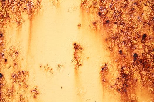 Rust covered weathered iron metal texture background with yellow peeling blistering paint