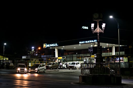Pune, Maharashtra, India - December 5th, 2018: Compressed Natural Gas filling station serving vehicles at night.