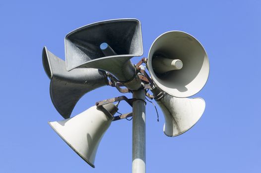 Close up of outdoor public address system consisting of five amplification megaphones