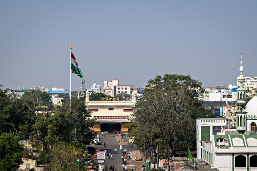 View of Hyderabad station with Indian flag and blue sky and vehicles traffic..