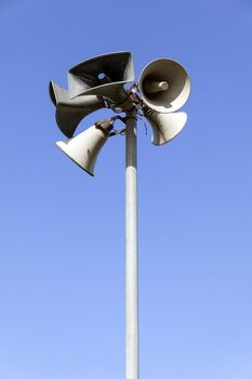 Close up of outdoor public address system consisting of five amplification megaphones