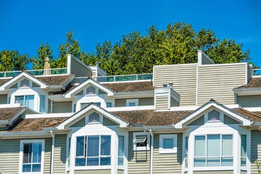 Top of residential townhouses on blue sky background