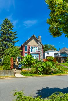 Beautiful suburban house with landscaped terrace and blue sky background. Residential house at sunny day in British Columbia